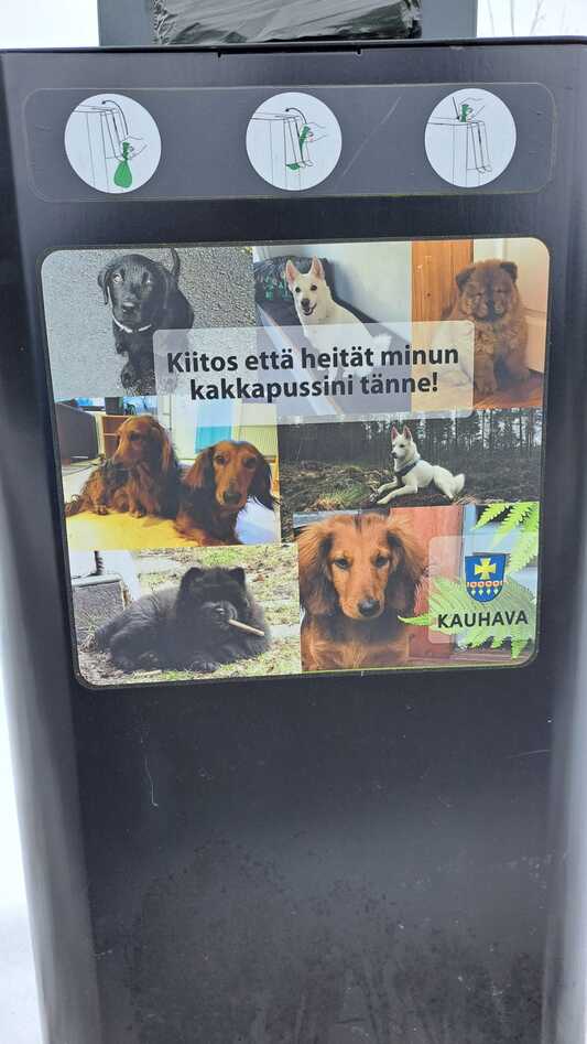 Kuvassa koirankakkaroskis, jonka kyljessä on koirien kuvia ja lukee "Kiitos, että heität kakkapussini tänne!"