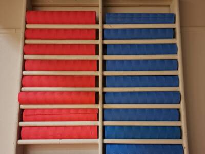 puolapuiden väleissä sinisiä ja punaisia jumppamattorullia