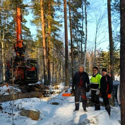 Kaivinkoneen vieressä metsässä miehiä