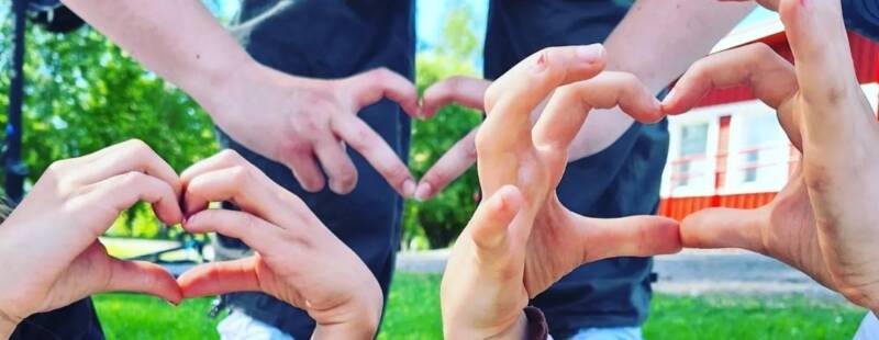 Nuorten tekemiä sydämen muotoisia käsimerkkejä.