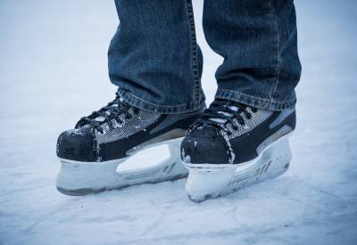 jalkojen alaosa, farkkulahkeet ja jalassa musta-harmaat luistimet (hokkarit)