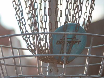vaaleansininen kiekko frisbeegolf häkissä